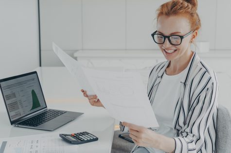Glad European female financier studies financial graphs diagrams counts expenses holds papers Glad European female financier studies financial graphs diagrams counts expenses holds papers