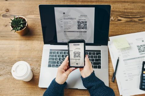Woman scanning QR code from invoice to make payment using fast secure payment system and smartphone Woman scanning QR code from invoice to make payment using fast secure payment system and smartphone